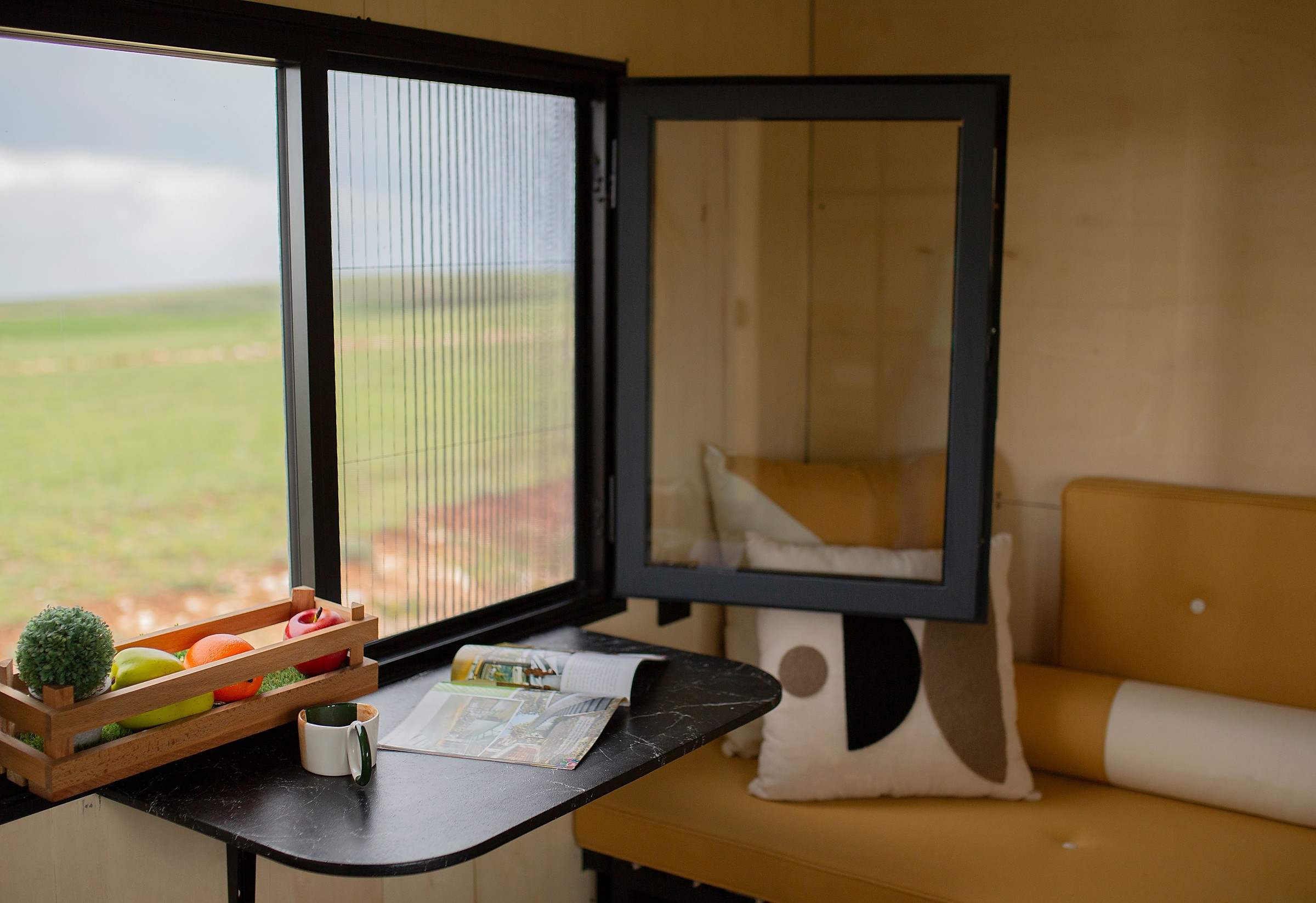 Compact tiny home dining nook beside a window